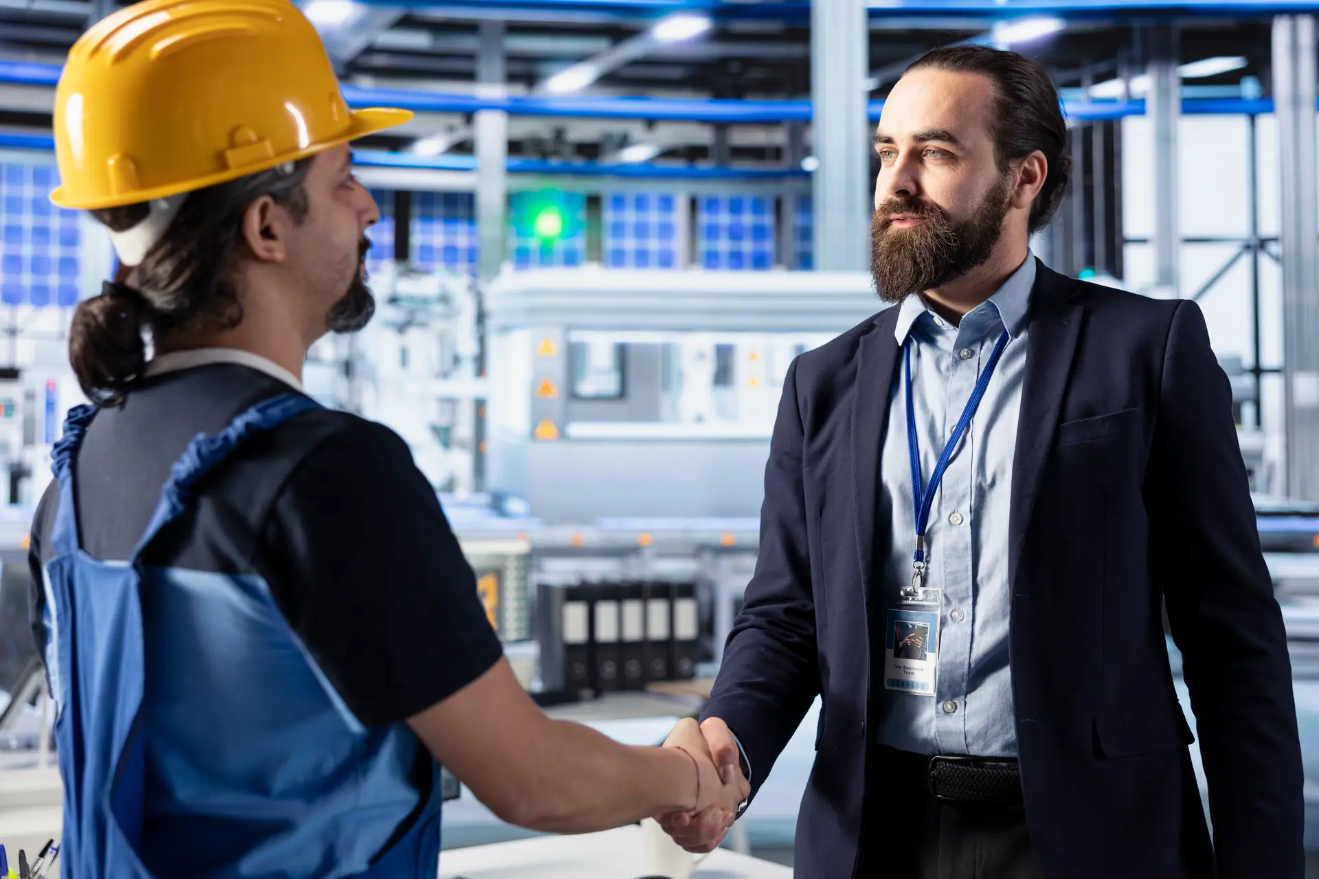 Poignée de main entre un dirigeant et un ingénieur en usine